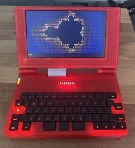 Un portátil rojo con luces bastante espartano muestra en pantalla una terminal donde hay pintado un fractal